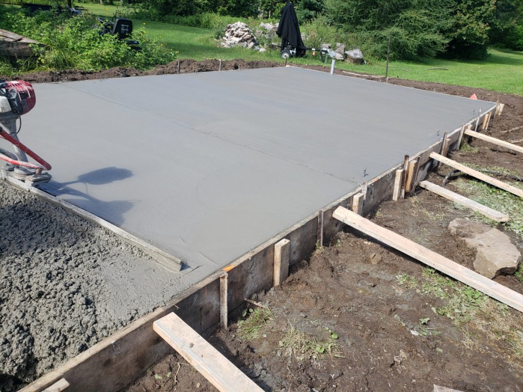 Wooden formwork and wire mesh laid out for garage floor reinforcement.