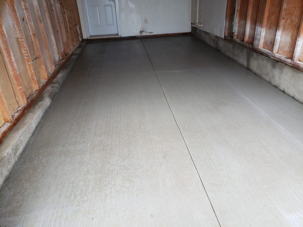 Saw-cut joints in freshly poured garage floor to control cracks in Ottawa climate.