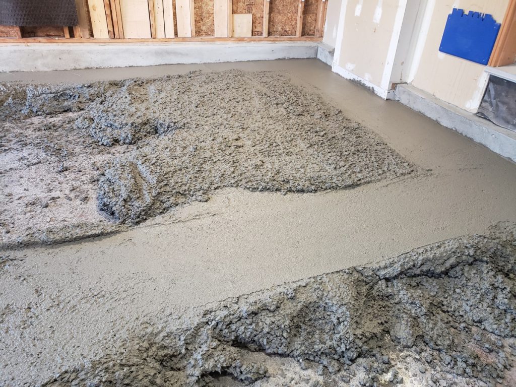 Fresh concrete being poured and levelled for a new garage floor in Ottawa.